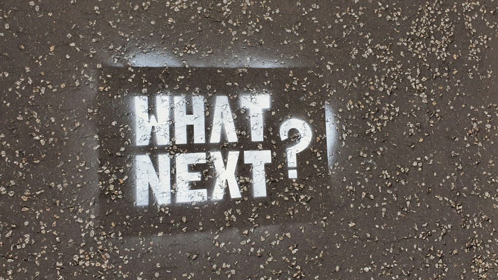 So, what's next? A stensil spray paint of the words What Next! on a pavement.