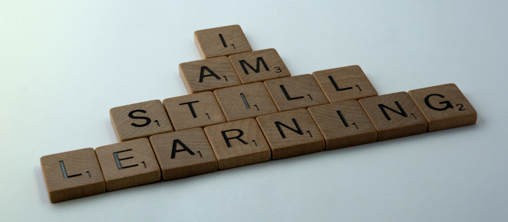 A photo of some scrabble tokens spelling out I Am Still Learning.